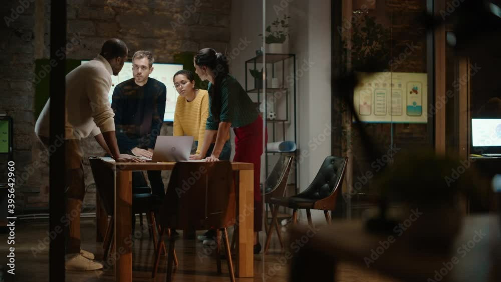 Diverse Multiethnic Team are Having a Conversation in a Meeting Room Behind Glass Walls in a Creative Office. Colleagues Lean On a Conference Table and Discuss Business, App User Interface and Design. Diverse Multiethnic Team are Having a Conversation in a Meeting Room Behind Glass Walls in a Creative Office. Colleagues Lean On a Conference Table and Discuss Business, App User Interface and Design.