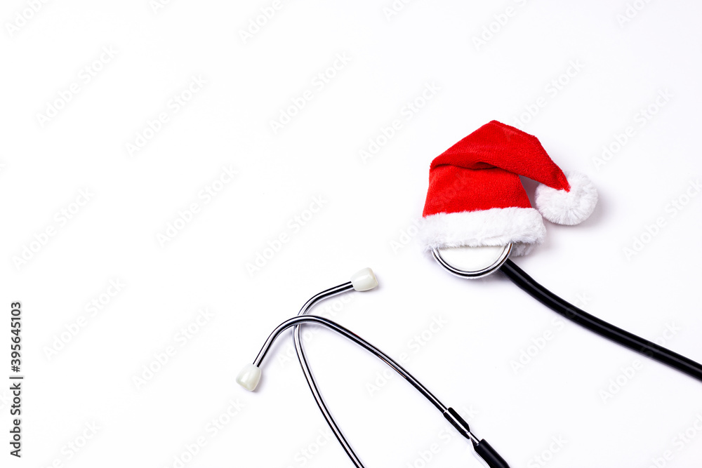 Christmas, New year's medical flat lay background. Stethoscope with Santa’s hat on light background. Medical stethoscope top view with copy space. Christmas, New year's medical flat lay background. Stethoscope with Santa’s hat on light background. Medical stethoscope top view with copy space.