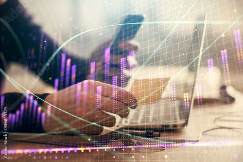 Double exposure of man's hands holding and using a phone and financial graph drawing. Analysis concept. © peshkova