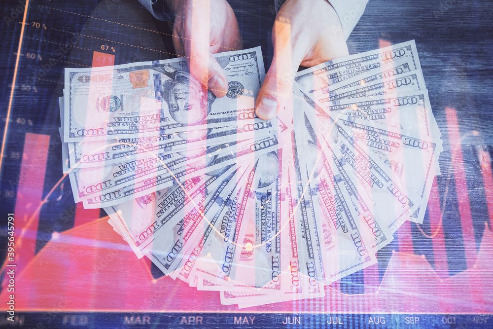 Multi exposure of financial graph drawing hologram and USA dollars bills and man hands. Analysis concept. Multi exposure of financial graph drawing hologram and USA dollars bills and man hands. Analysis concept.