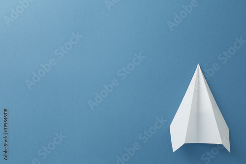 White paper airplane on a blue background