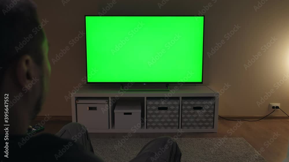 Watching tv with green screen at home. Man watches television Watching tv with green screen at home. Man watches television