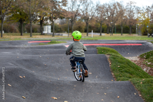 Fototapeta Naklejka Na Ścianę i Meble -  Handsome little boy driving bicycle on a track
