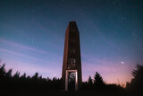 Lookout tower on hill Velka Destna in Czech republic at night with visible stars and colorful sky