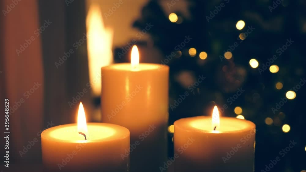 Burning candles. Christmas celebration in cozy interior with decorated new year tree. Winter holidays Burning candles. Christmas celebration in cozy interior with decorated new year tree. Winter holidays