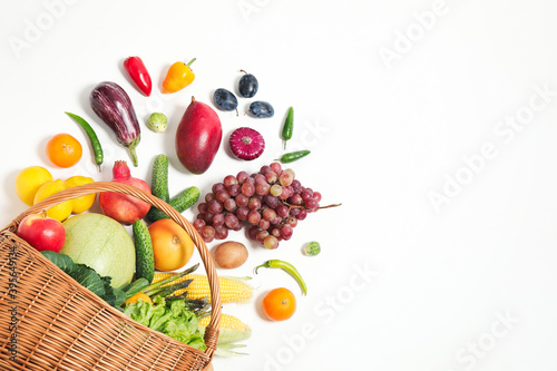 Fototapeta Naklejka Na Ścianę i Meble -  Basket with assortment of fresh organic fruits and vegetables on white background, top view