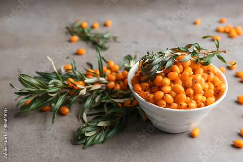 Fresh ripe sea buckthorn in bowl on grey table photo