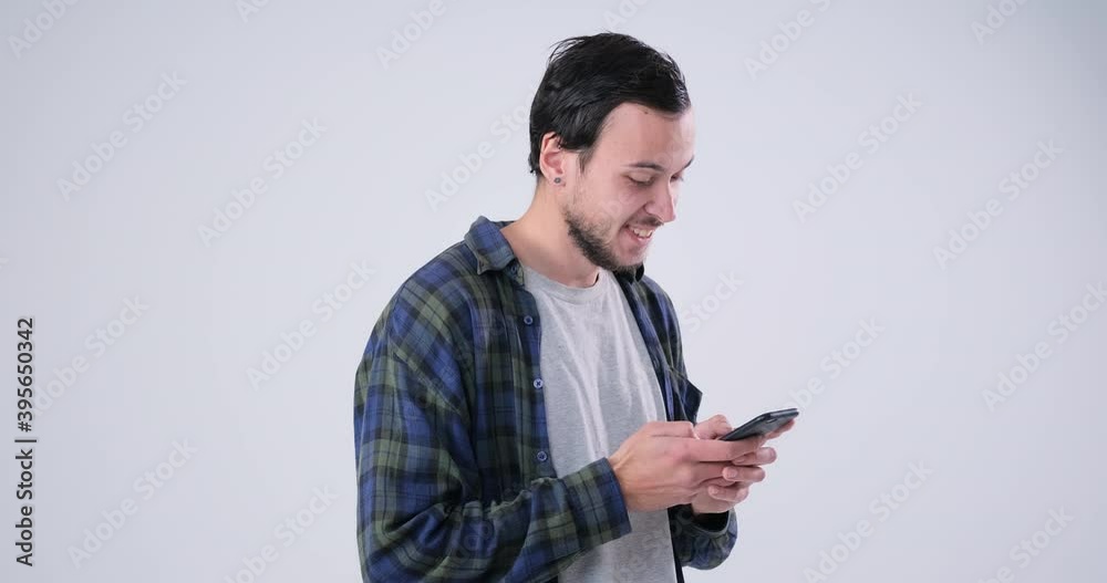 Pleased men text messaging on mobile phone at white background Pleased men text messaging on mobile phone at white background