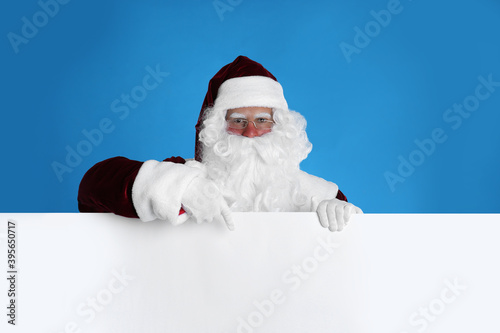 Santa Claus holding empty banner on light blue background © New Africa