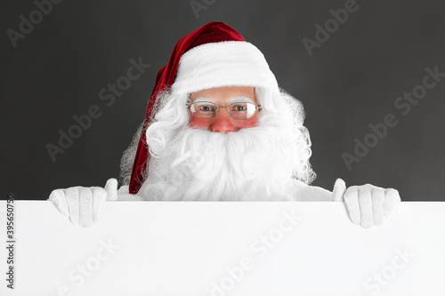 Santa Claus holding empty banner on black background