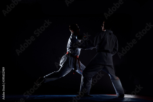 Two judoka fighter man in kimono practicing in the gym