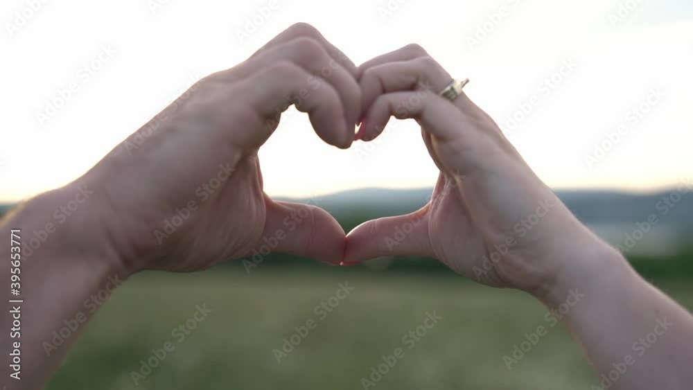 A nice couple love shape hand silhouette at sunset A nice couple love shape hand silhouette at sunset