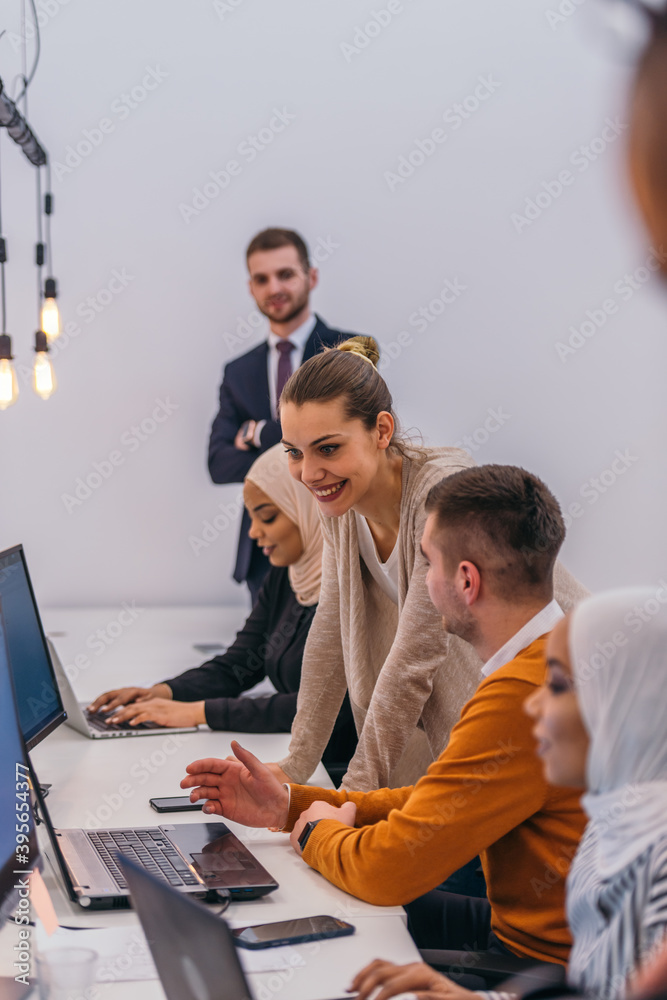 Obraz premium Young business colleagues working together on a computer in a comfortable office atmosphere.