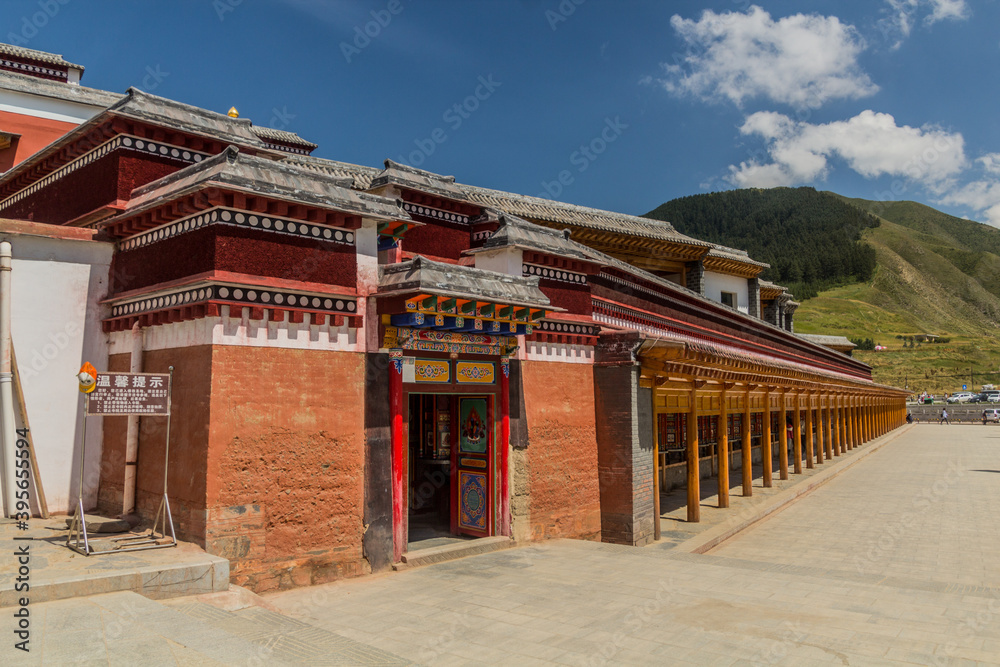 XIAHE, CHINA - AUGUST 24, 2018: Row of prying wheels at Labrang Monastery in Xiahe town, Gansu province, China