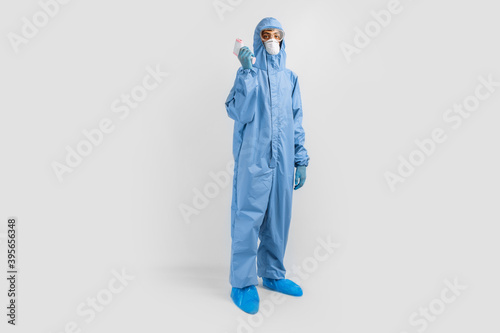 Wallpaper Mural Full-length male doctor wearing protective clothing, glasses, mask and gloves, with a non-contact thermometer to measure temperature, on a white background, coronavirus epidemic concept Torontodigital.ca
