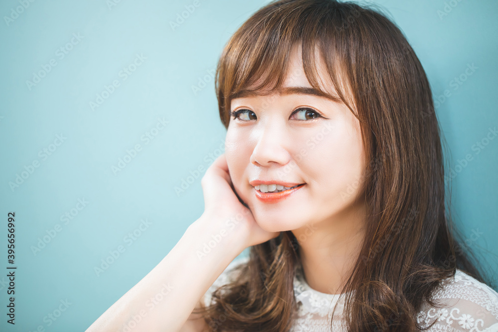 カットモデル／水色の壁の前にいる女性
