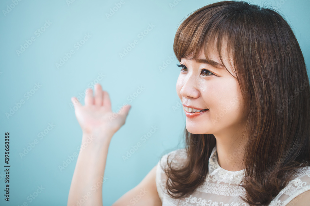 水色の壁の前にいる女性
水色の壁の前にいる女性