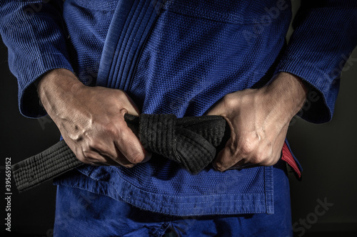 Obraz na plátně Close up on hand of unknown caucasian man holding brazilian jiu jitsu bjj black