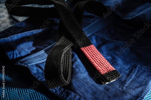 Fotografija Close up on brazilian jiu jitsu bjj black belt on the blue kimono gi on tatami m