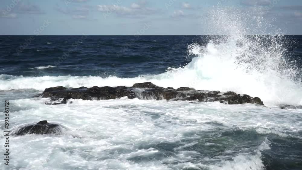 Stormy waves hitting the rocks. Sunny, windy day in season of summer. Stormy waves hitting the rocks. Sunny, windy day in season of summer.