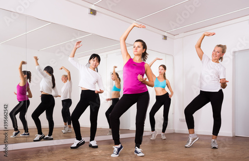 Cheerful different ages women learning swing steps at dance class. High quality photo