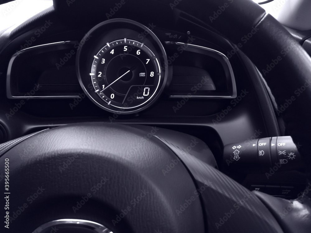 Close-up car speed dashboard with steering wheel in car.