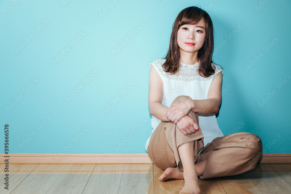 水色の壁の前にいる女性
水色の壁の前にいる女性