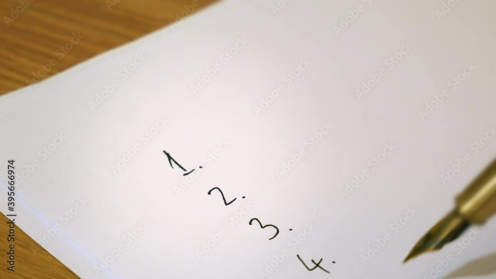 Numbers are written in a list on a blank sheet of paper with a fountain pen in ink.