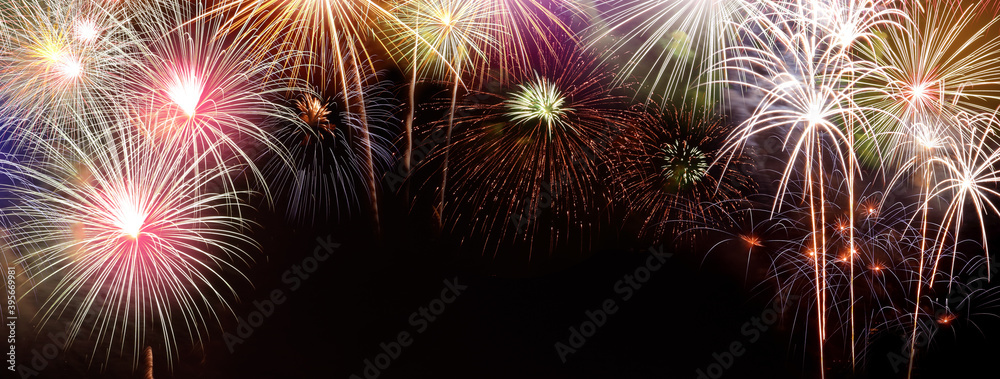 Fototapeta premium Fireworks happy new year Many colorful colors stacked on a black background In the middle there is a space for writing messages.