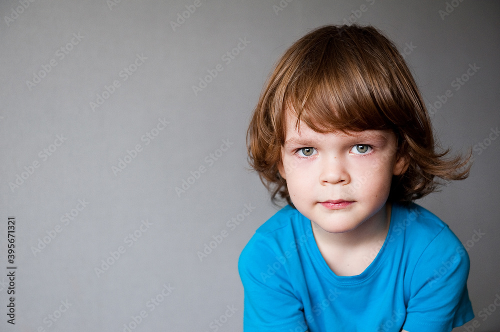 Portrait of a cute child on a gray background with space for advertising text.