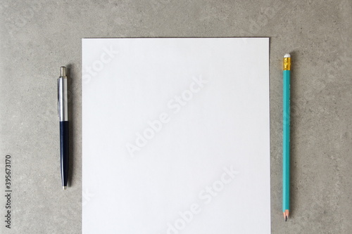 Template of white paper with a ballpoint pen and simple pencil on light grey concrete background. Concept of new idea, business plan and strategy,  empty space for text