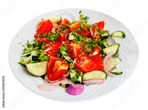 Delicious summer salad of cucumbers and tomatoes on a plate. Isolated over white background