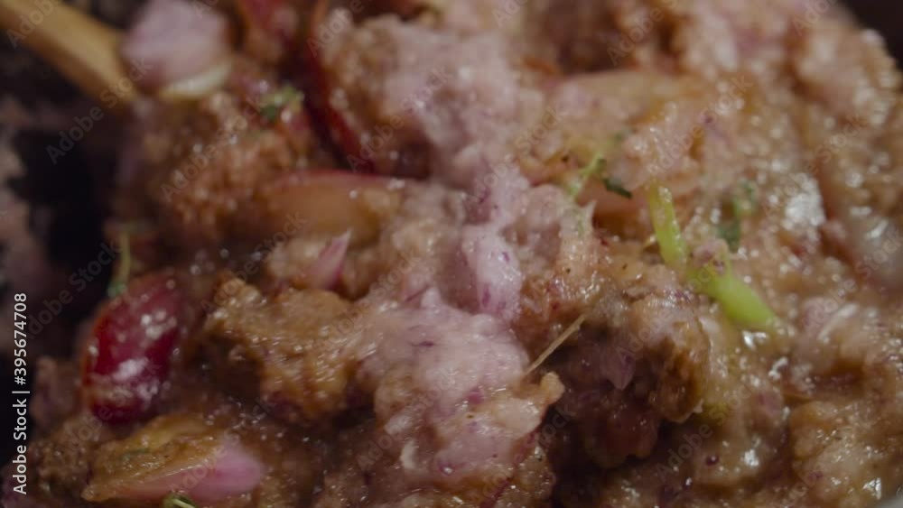 Mixing Alla Genovese sauce with beef shank, onion slices, celery and spices inside a deep cooking pot. Close up shot. Slow motion. Mixing Alla Genovese sauce with beef shank, onion slices, celery and spices inside a deep cooking pot. Close up shot. Slow motion.