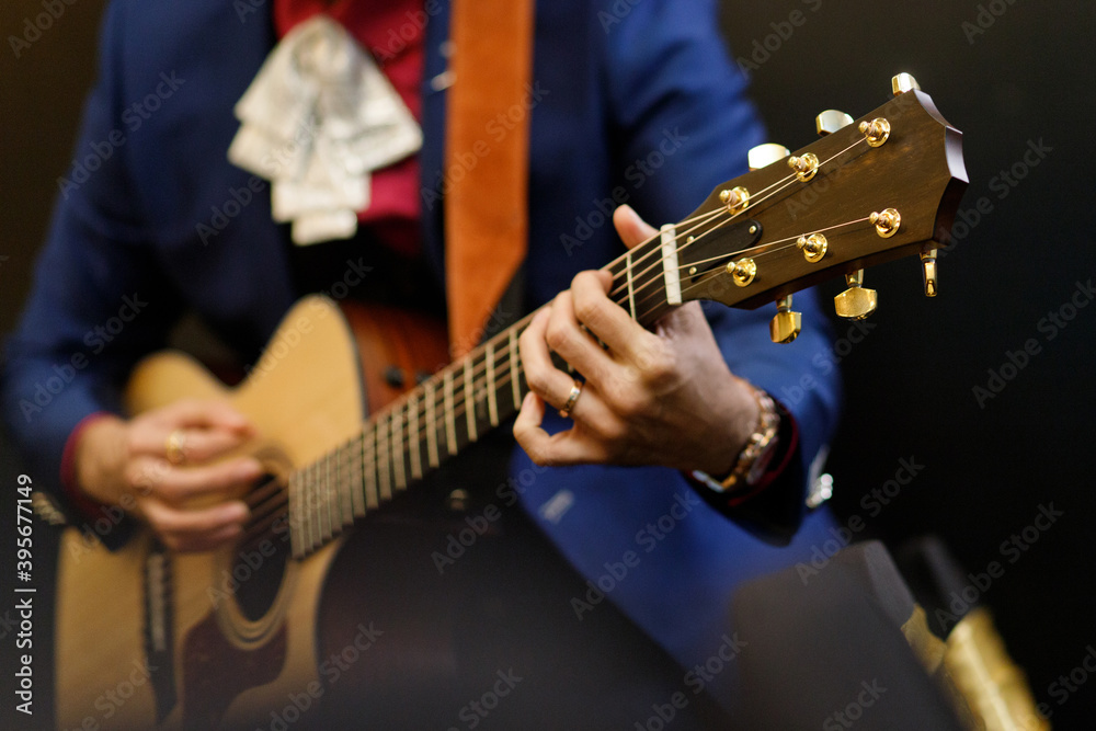 Close photo of a man playing classical guitar.