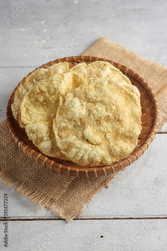 Emping Melinjo is Indonesian Traditional Crackers in woven bamboo plate made from Melinjo or Belinjo (Gnetum gnemon) Nut. photo