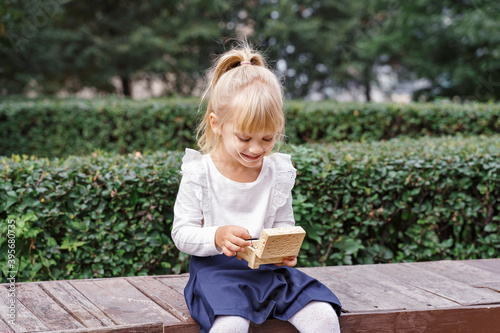 cute blonde girl with wooden little casket outdoor