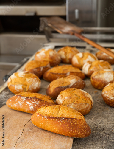 Crispy hot bread on table in bakery, fresh bread from industrial oven