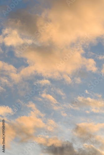 Colorful blue sky and clouds highlighted by setting sun, as a nature background 