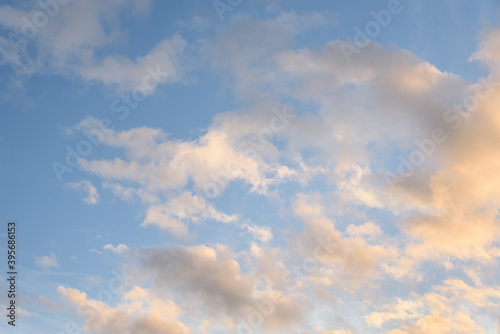Colorful blue sky and clouds highlighted by setting sun, as a nature background 