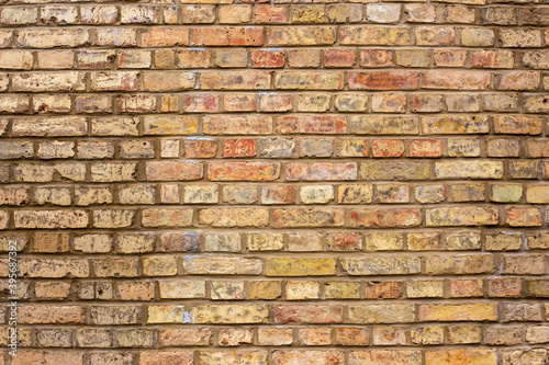 A wall of old yellow and brown bricks.