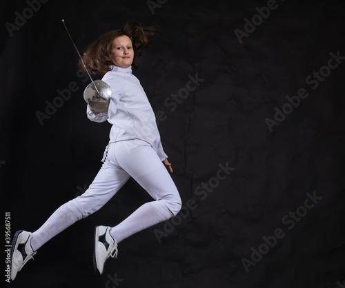 Teenage girl fencer dressed in uniform with epee and helmet