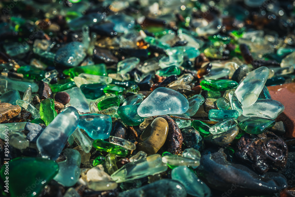 Natural background with sea glass close-up on sand.
