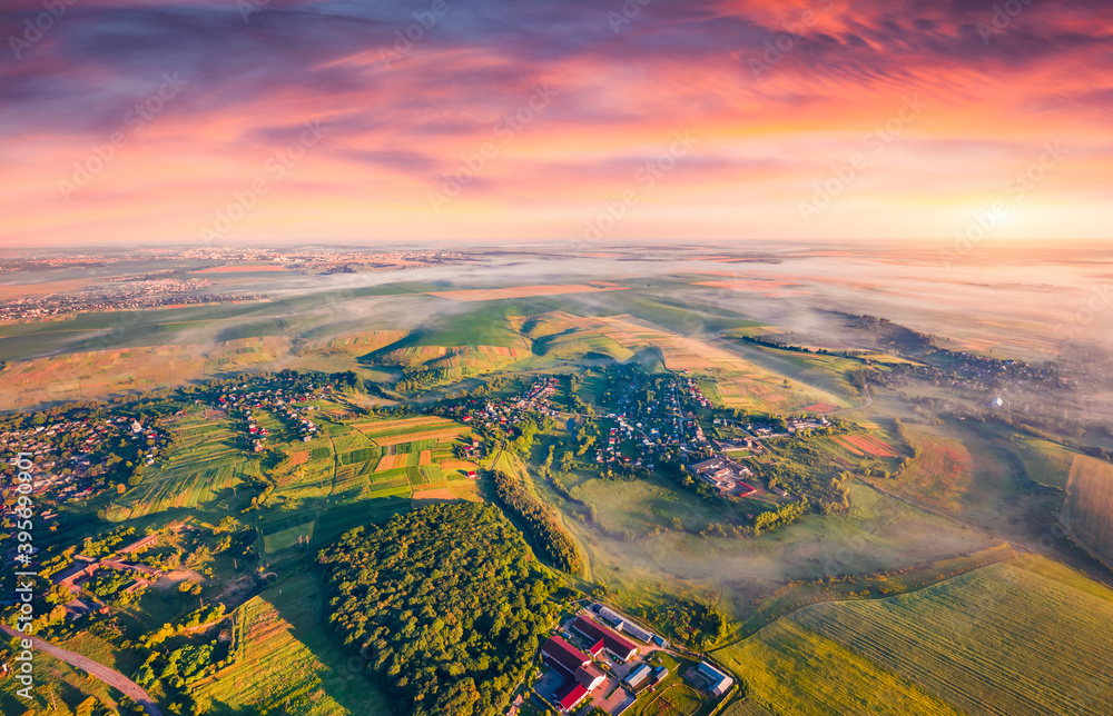Rural landscape photography. Foggy autumn sunrise on countryside. Captivating morning view from flying drone of village and plowed field, Ternopil region, Ukraine, Europe.