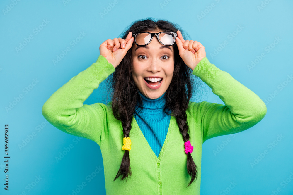 Photo of happy nice amazed young woman hold fingers glasses surprised reaction isolated on shine blue color background Photo of happy nice amazed young woman hold fingers glasses surprised reaction isolated on shine blue color background