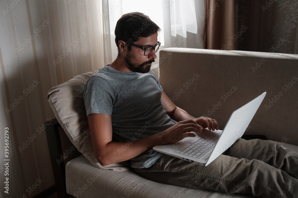 Remote Job. Man Working On Laptop Sitting On Sofa At Home. Remote Job. Man Working On Laptop Sitting On Sofa At Home.