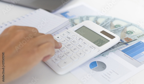 Business man's hand is pressing the calculator