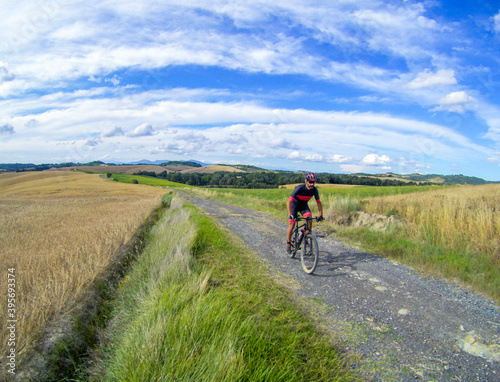 A biker on a classic white road of Tuscany