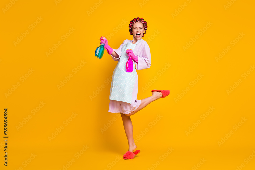Full length body size view of pretty cheerful overjoyed maid jumping using sanitizer isolated on bright yellow color background Full length body size view of pretty cheerful overjoyed maid jumping using sanitizer isolated on bright yellow color background