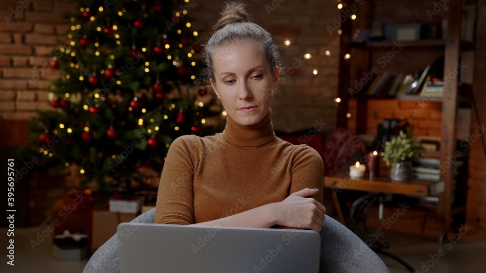 Woman working on laptop computer at home in winter at Christmas in December, Winter. Woman working on laptop computer at home in winter at Christmas in December, Winter.