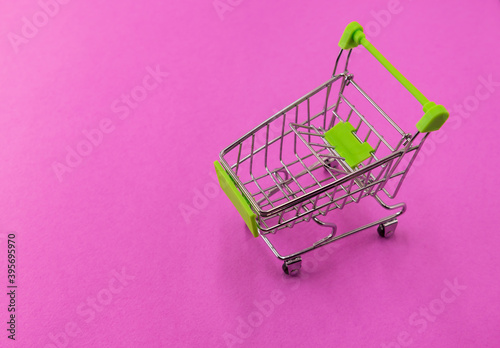 an empty shopping basket stands on a colored background
